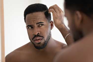 male-checks-hair-in-mirror
